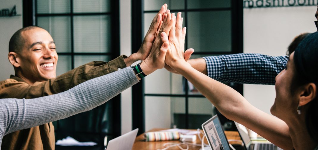 Software development team high five hands together